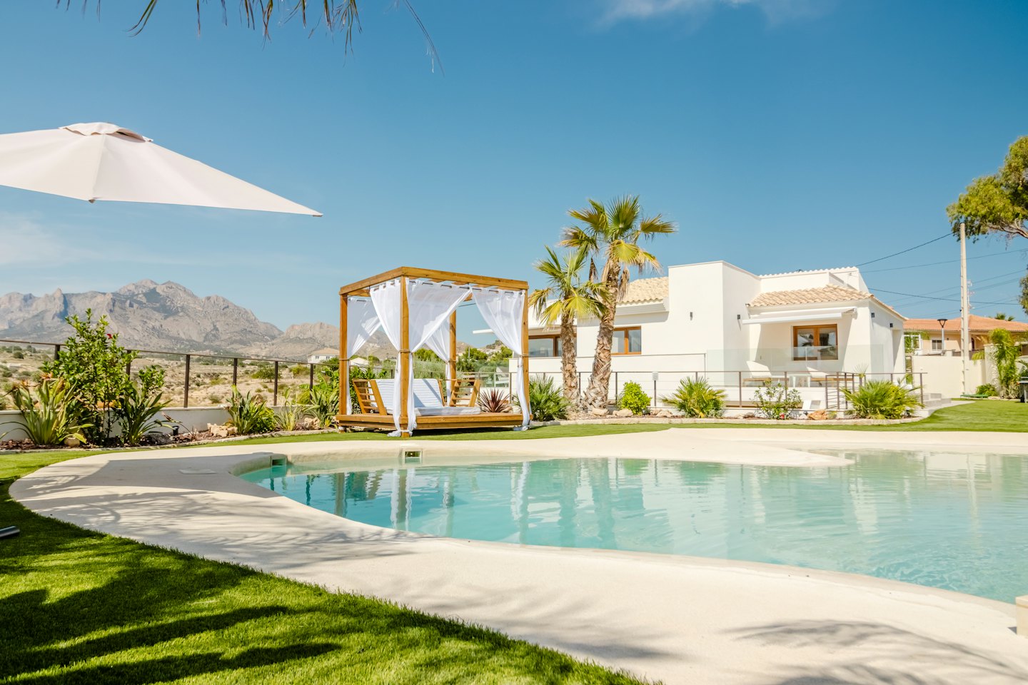 Luxe vakantievilla met zwembad en houten prieel.