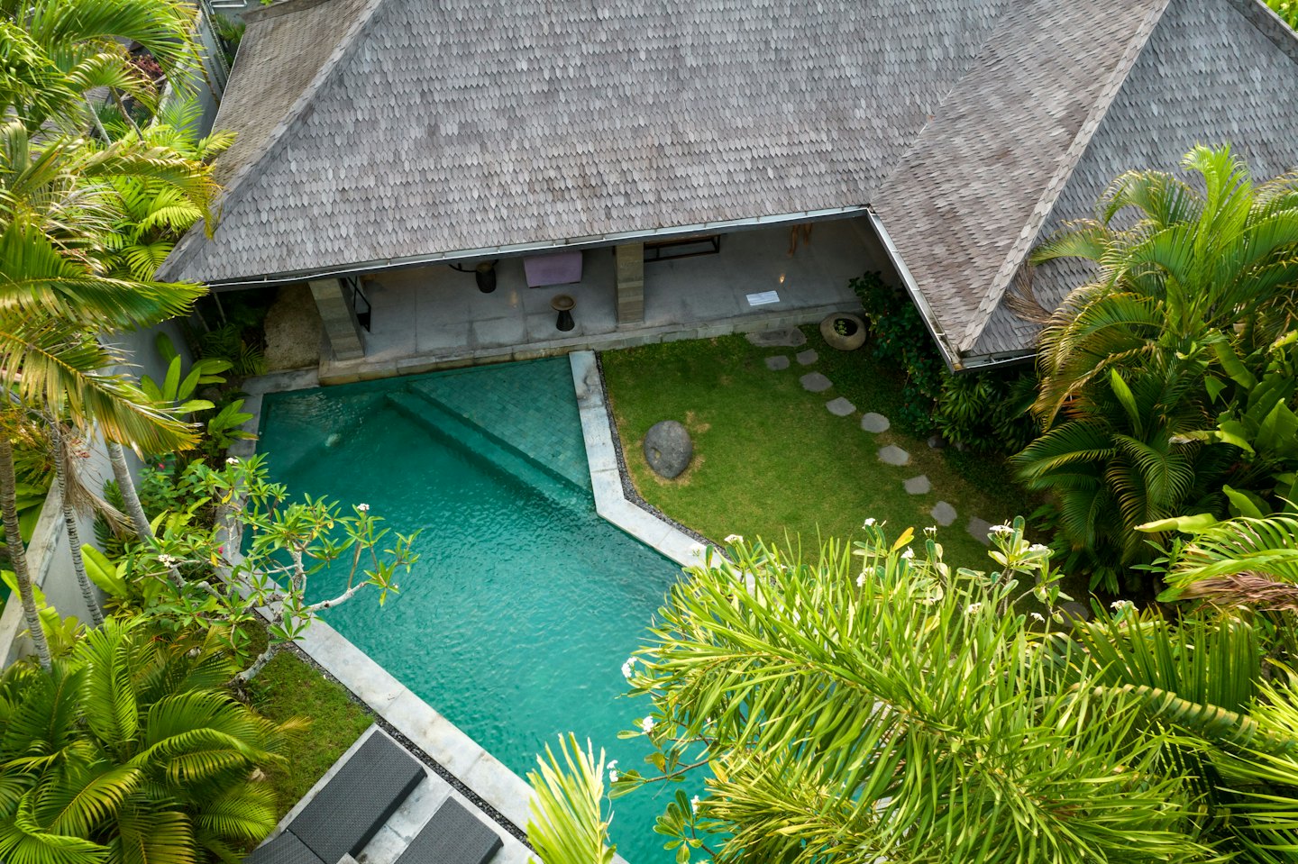 Tropische villa met zwembad en palmbomen.