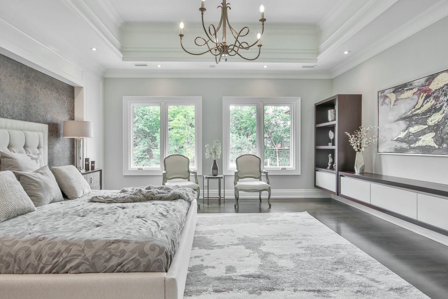 Luxe hoofdslaapkamer met kingsize bed en uitzicht op bomen.