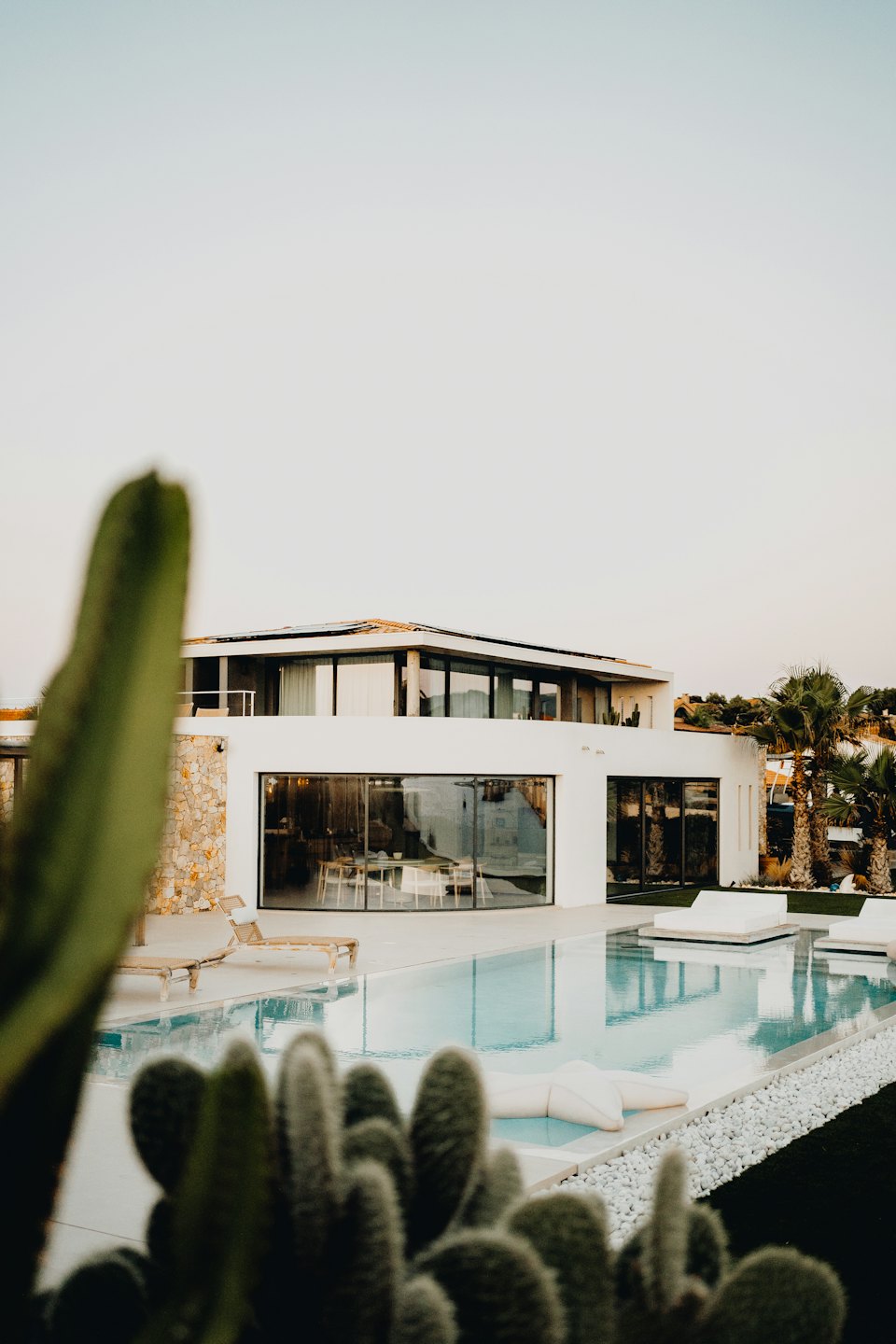 Moderne witte villa met zwembad en zonnepanelen.