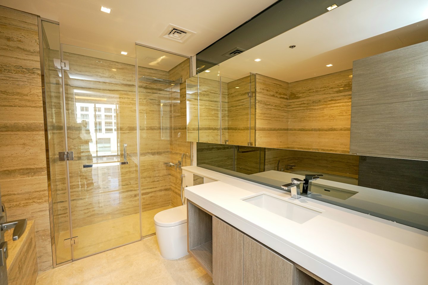 Moderne badkamer met inloopdouche van steen en wit badmeubel.